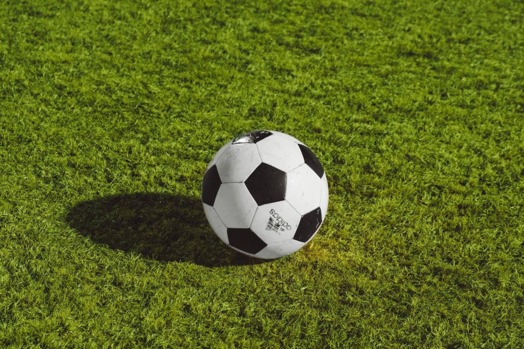 A football in the middle of a green field